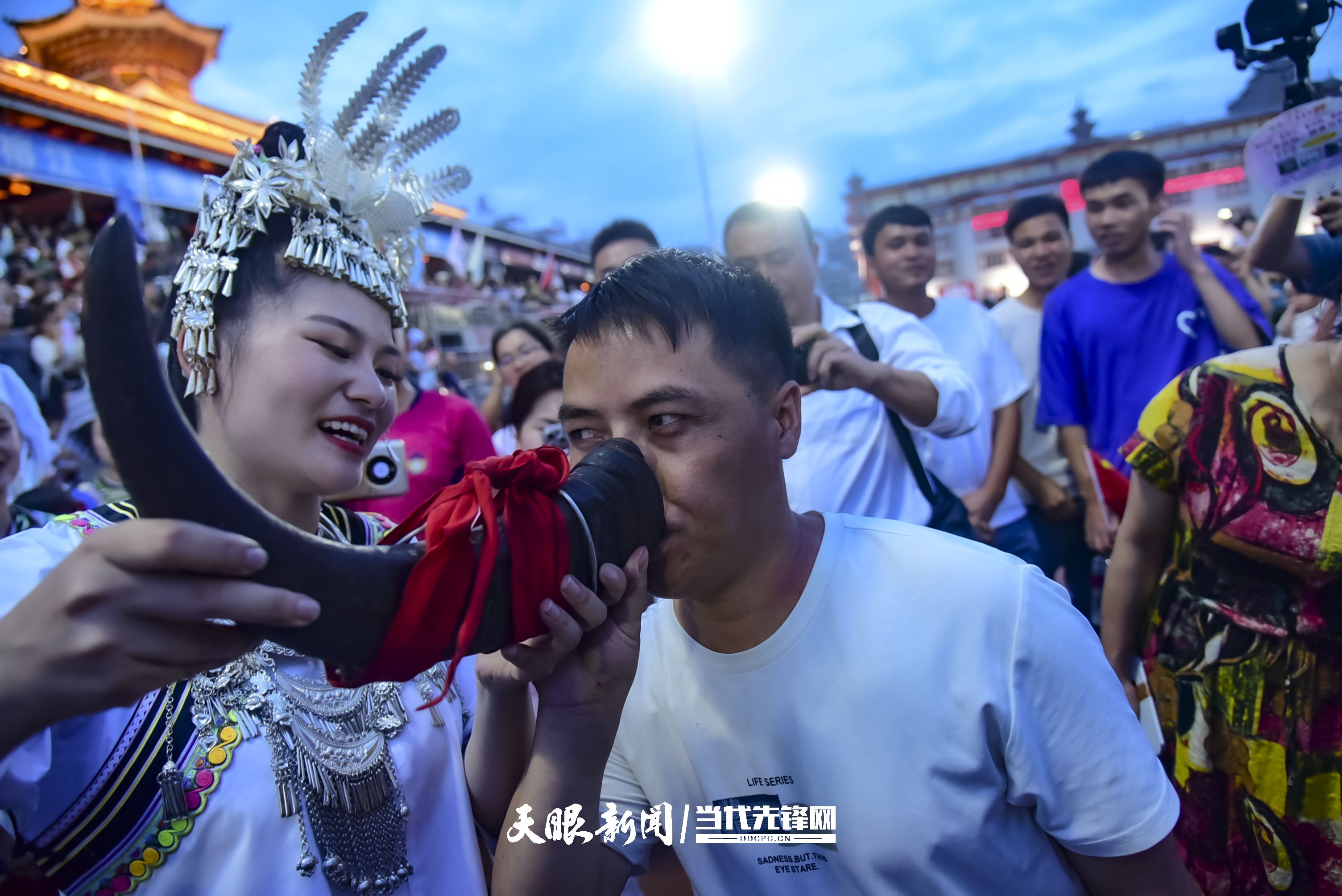 村超現(xiàn)場(chǎng)，當(dāng)?shù)厝罕娤蜻h(yuǎn)道而來(lái)的游客敬酒。 潘邵平 攝.jpg